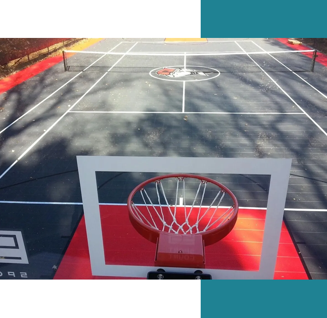 A basketball hoop on the side of an asphalt court.