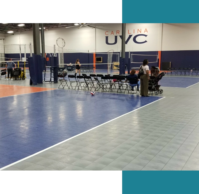 A group of people sitting on top of a volleyball court.