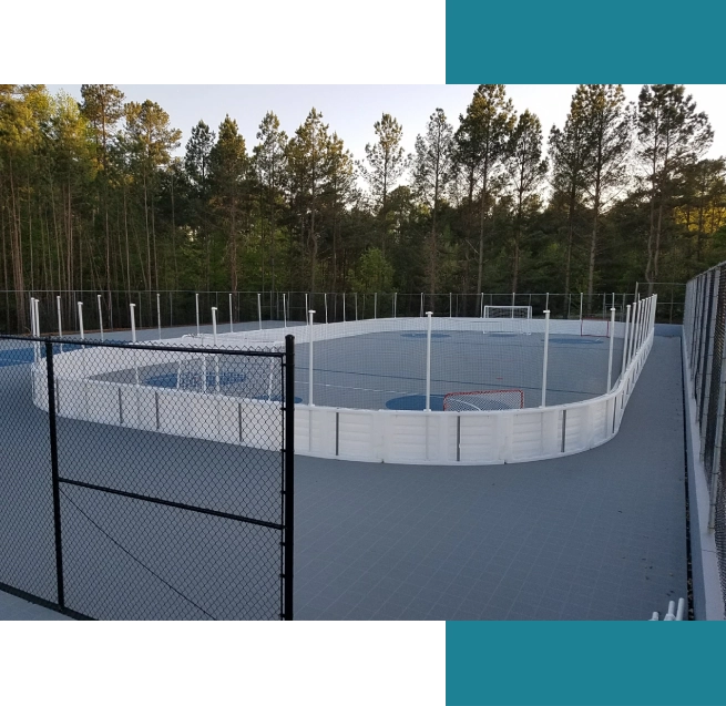 A view of an ice rink with trees in the background.