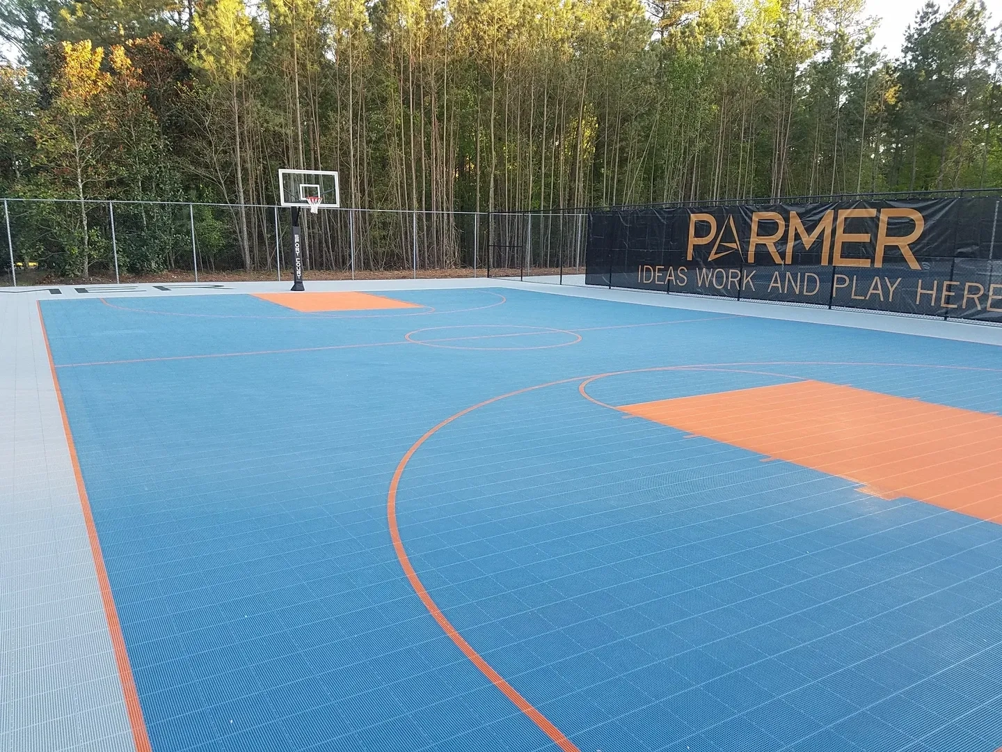 A basketball court with trees in the background.