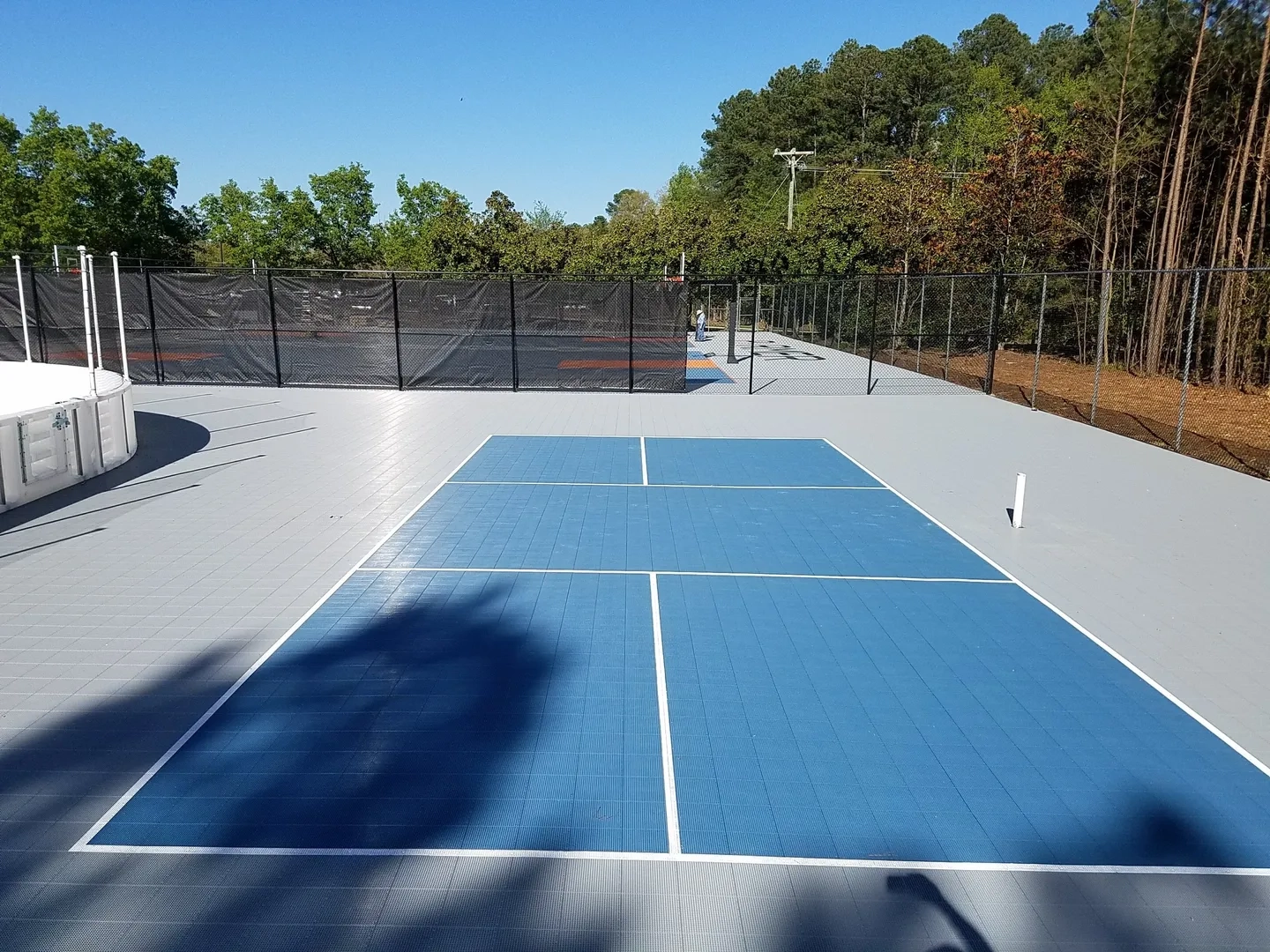 A tennis court with blue and white lines.