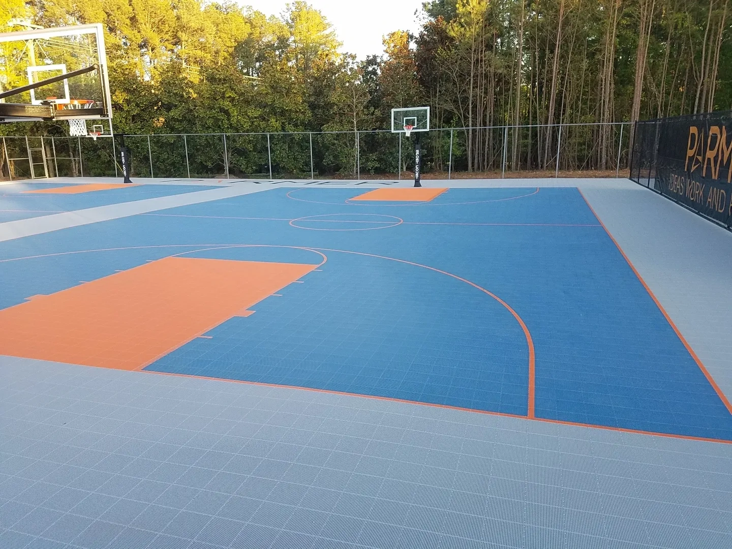 A basketball court with trees in the background.