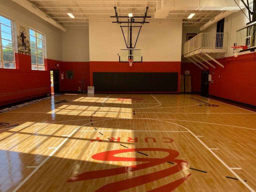 A gym with basketball hoops and a net.